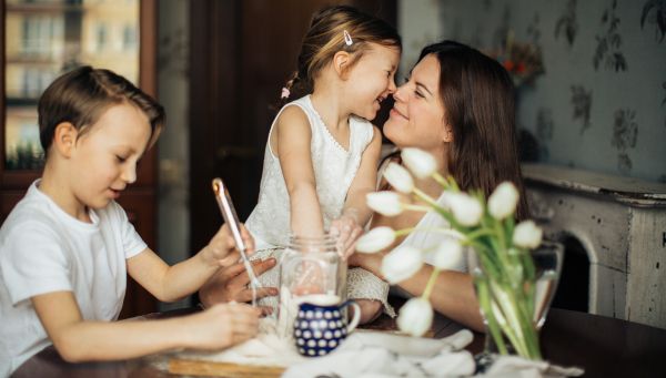 mamma con bambini che sorridono in cucina